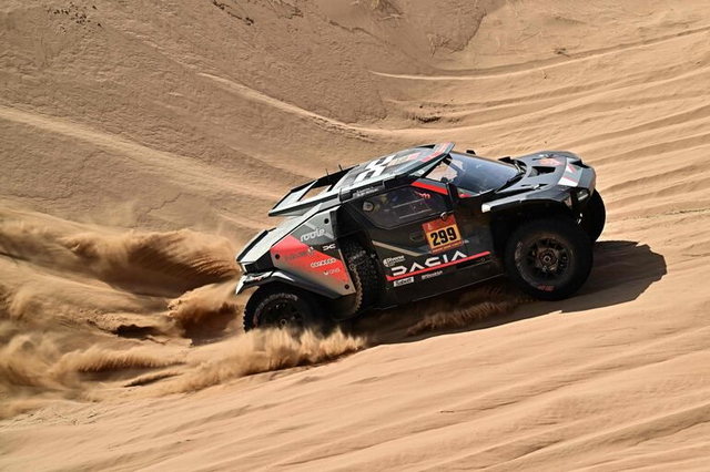 Vista de un rally del Dakar con vehículos recorriendo un terreno desértico.