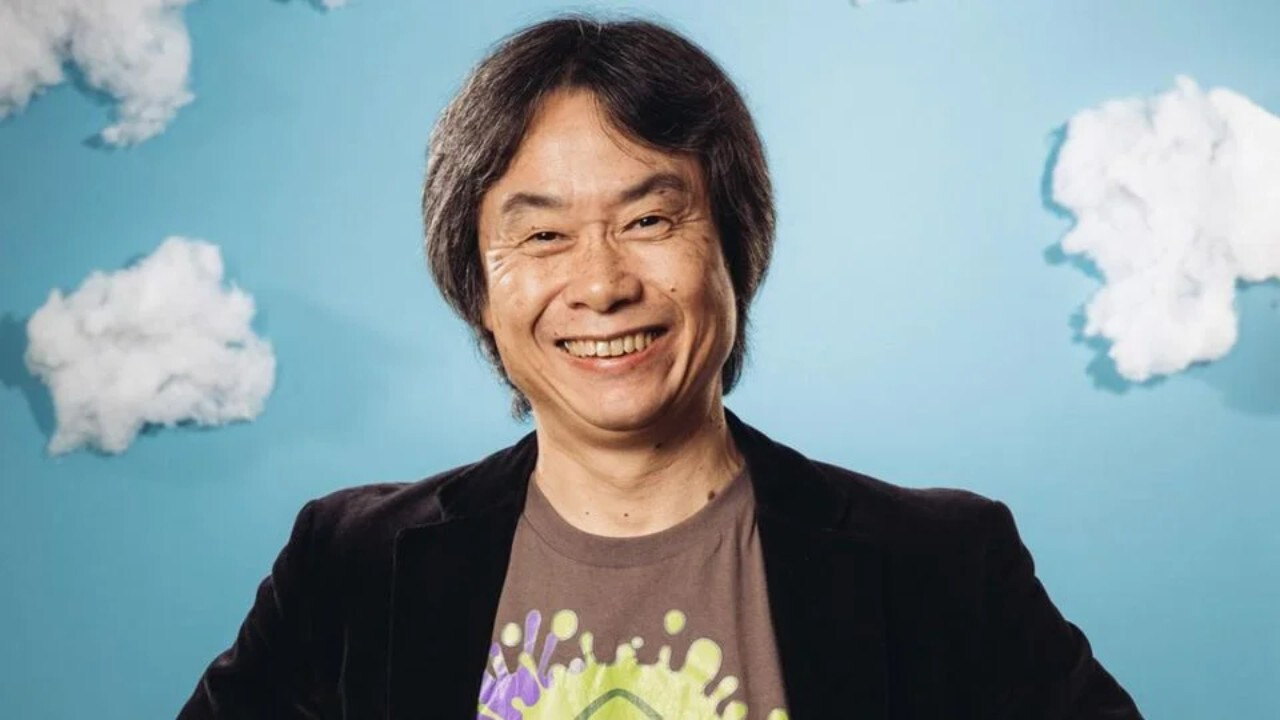 Shigeru Miyamoto posando junto a una figura de Mario